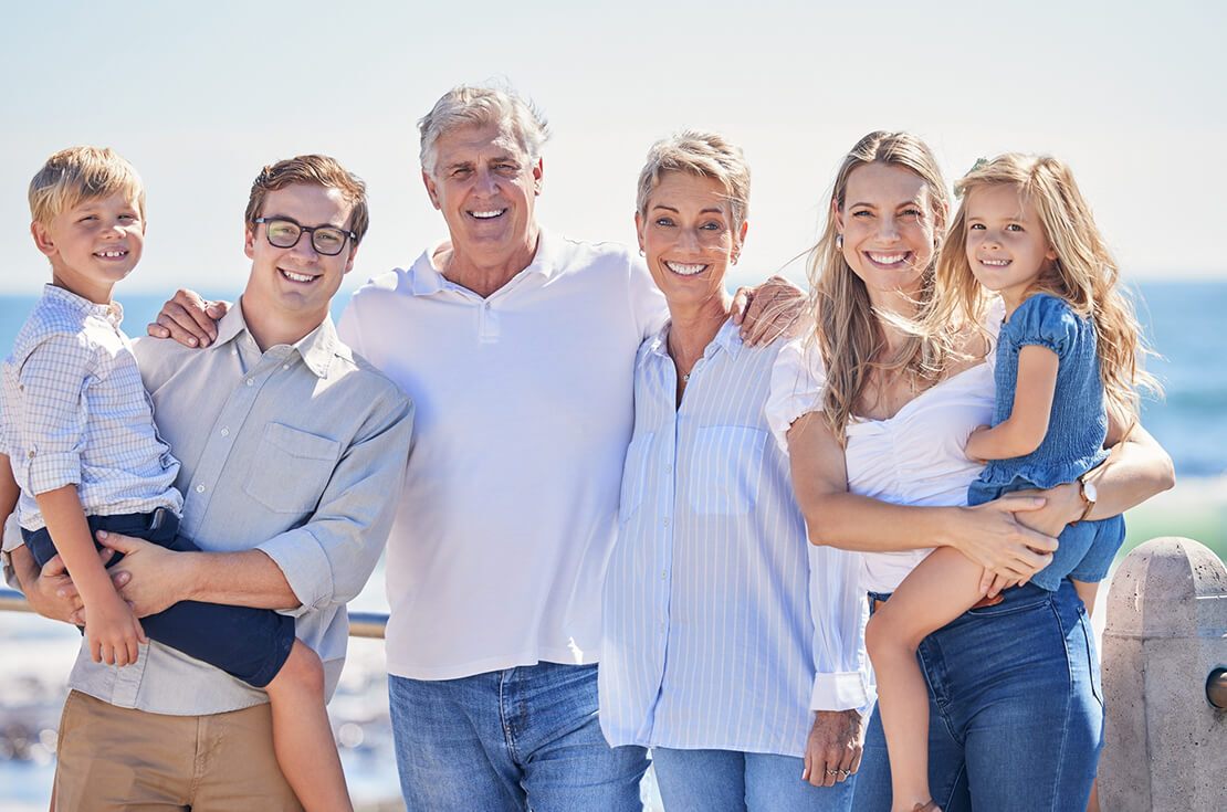 multi-generation family standing together on seaside